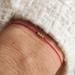 Bransoletka pozłacana na czerwonym sznurku na szczęście z trzema kuleczkami